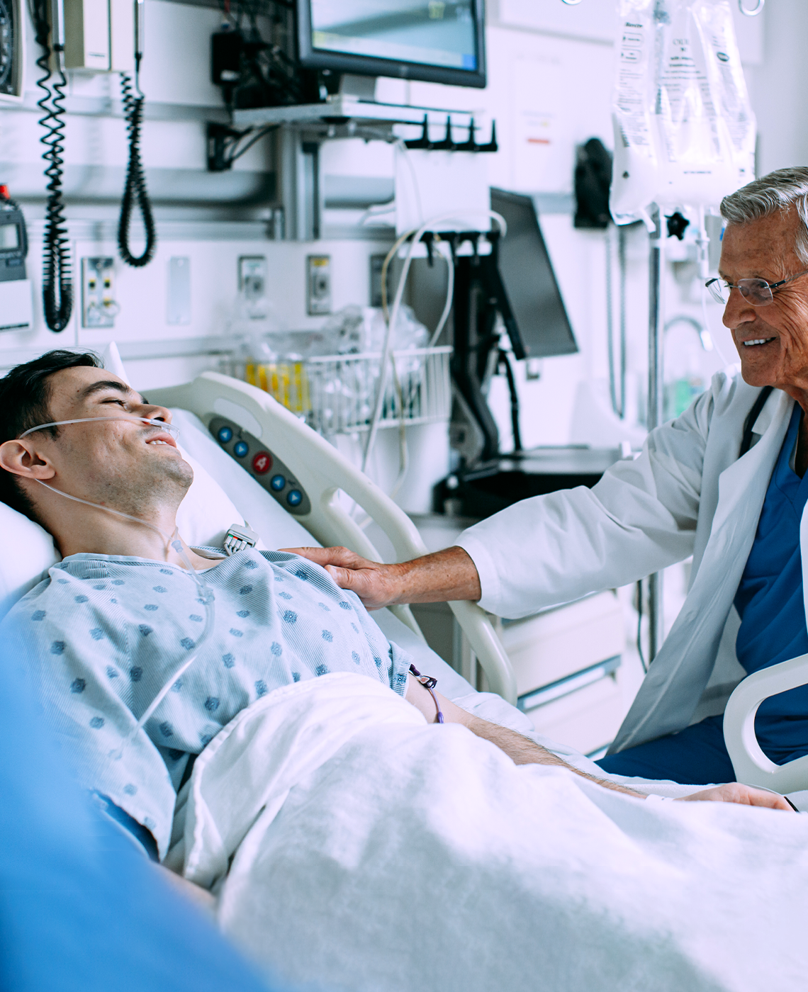 Healthcare professional assisting a patient in a hospital bed
