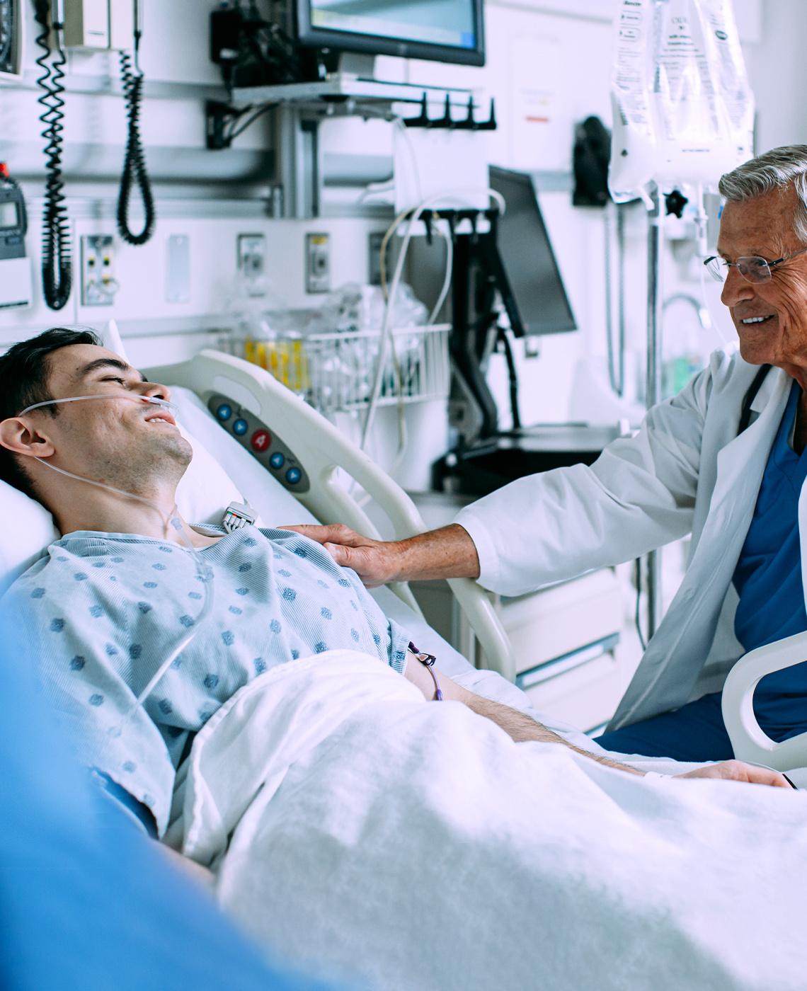 Healthcare professional assisting a patient in a hospital bed